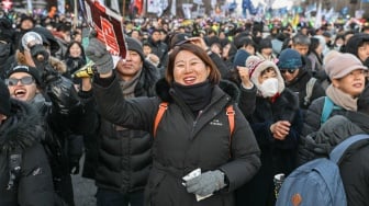 Reaksi para pengunjuk rasa yang menuntut pemecatan Presiden Korea Selatan Yoon Suk Yeol setelah hasil pemungutan suara pemakzulan dirinya di luar Majelis Nasional di Seoul, Korea Selatan, Sabtu (14/12/2024). [ANTHONY WALLACE / AFP]