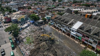 Foto udara alat berat yang dioperasikan petugas meratakan sampah yang menumpuk di Pasar Induk Caringin, Bandung, Jawa Barat, Kamis (19/12/2024). [ANTARA FOTO/Raisan Al Farisi/Spt]