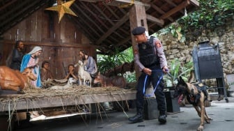 Anggota kepolisian melakukan sterilisasi di Gereja Katedral Jakarta atau Gereja Santa Maria Diangkat Ke Surga menjelang perayaan Hari Raya Natal di Jakarta, Selasa (24/12/2024). [Suara.com/Alfian Winanto]