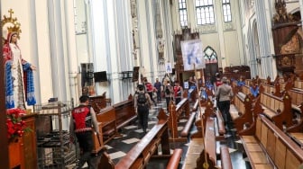 Anggota kepolisian melakukan sterilisasi di Gereja Katedral Jakarta atau Gereja Santa Maria Diangkat Ke Surga menjelang perayaan Hari Raya Natal di Jakarta, Selasa (24/12/2024). [Suara.com/Alfian Winanto]