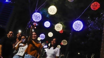 Pejalan kaki melintas di trotoar Jalan Jenderal Sudirman, Jakarta, Rabu (25/12/2024). [Suara.com/Alfian Winanto]