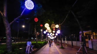 Pejalan kaki melintas di trotoar Jalan Jenderal Sudirman, Jakarta, Rabu (25/12/2024). [Suara.com/Alfian Winanto]