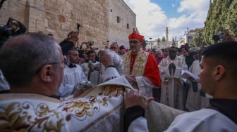 Patriark Latin Yerusalem Pierbattista Pizzaballa (tengah) memimpin prosesi Natal tahunan di luar Gereja Kelahiran di kota Betlehem di Tepi Barat Palestina yang diduduki Israel pada Selasa (24/12/2024). [HAZEM BADER / AFP]