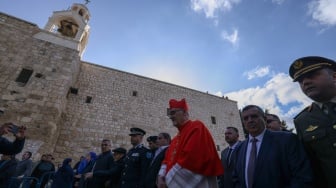 Patriark Latin Yerusalem Pierbattista Pizzaballa (tengah) memimpin prosesi Natal tahunan di luar Gereja Kelahiran di kota Betlehem di Tepi Barat Palestina yang diduduki Israel pada Selasa (24/12/2024). [HAZEM BADER / AFP]