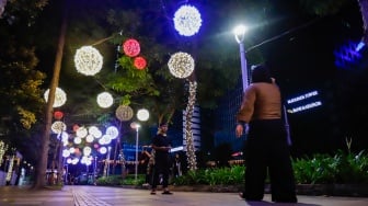 Pejalan kaki melintas di trotoar Jalan Jenderal Sudirman, Jakarta, Rabu (25/12/2024). [Suara.com/Alfian Winanto]