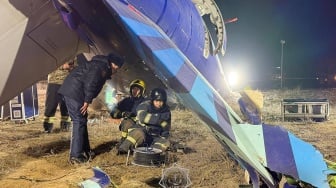 Petugas mengevakuasi puing-puing di lokasi jatuhnya pesawat penumpang Azerbaijan Airlines di dekat kota Aktau di Kazakhstan barat, Kamis (26/12/2024).  [Handout / Kazakhstan's emergency situations ministry / AFP]