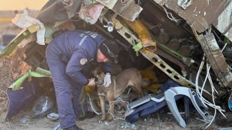 Petugas mengevakuasi puing-puing di lokasi jatuhnya pesawat penumpang Azerbaijan Airlines di dekat kota Aktau di Kazakhstan barat, Kamis (26/12/2024). [Handout / Kazakhstan's emergency situations ministry / AFP]