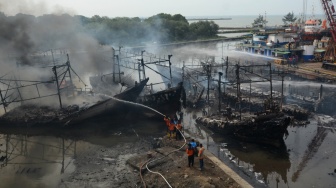 Foto udara kondisi kapal nelayan yang terbakar di Pelabuhan Tegal, Jawa Tengah, Jumat (27/12/2024). [ANTARA FOTO/Oky Lukmansyah/rwa]