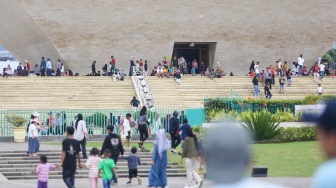 Pengunjung berwisata di kawasan Monas, Jakarta, Jumat (27/12/2024). [Suara.com/Alfian Winanto]