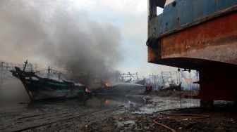 Petugas berusaha memadamkan api saat kebakaran kapal nelayan di Pelabuhan Tegal, Jawa Tengah, Jumat (27/12/2024). [ANTARA FOTO/Oky Lukmansyah/nym] 