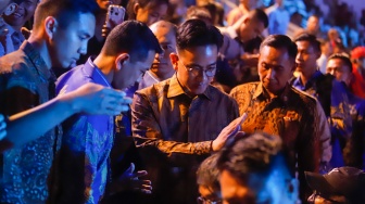 Wakil Presiden Gibran Rakabuming Raka menyapa umat nasrani saat menghadiri Perayaan Natal Nasional 2024 yang berlangsung di Indonesia Arena, Jakarta, Sabtu (28/12/2024). [Suara.com/Alfian Winanto]