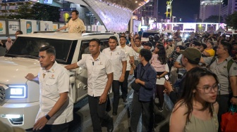 Presiden Prabowo Subianto menyapa warga dari atas mobilnya saat car free night di kawasan Bundaran HI, Jakarta, Selasa (31/12/2024). [ANTARA FOTO/Fauzan/foc]