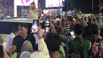 Presiden Prabowo Subianto menyapa warga dari atas mobilnya saat car free night di kawasan Bundaran HI, Jakarta, Selasa (31/12/2024). [ANTARA FOTO/Fauzan/foc]