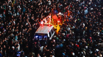 Mobil Ambulans mencoba melewati kerumuna warga saat Car Free Night menyambut malam pergantian tahun di Bundaran HI, Jakarta, Selasa (31/12/2024). [Suara.com/Alfian Winanto]