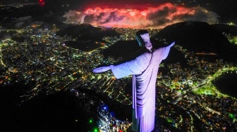 Pemandangan udara ini memperlihatkan patung Kristus Sang Penebus saat kembang api meledak di seluruh kota selama perayaan Tahun Baru di Rio de Janeiro, Brasil, Rabu (1/1/2025). [Mauro PIMENTEL / AFP]