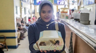Pengunjung menunjukan es krim yang dibelinya di Ragusa Es Italia di Jakarta, Rabu (1/1/2025). [Suara.com/Alfian Winanto]