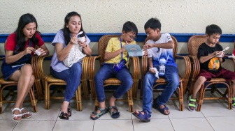 Pengunjung menikmati es krim di Ragusa Es Italia di Jakarta, Rabu (1/1/2025). [Suara.com/Alfian Winanto]