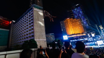 Suasana pertunjukan Drone Light Show saat malam perayaan tahun baru 2025 kawasan Bundaran HI, Jakarta, Rabu (1/1/2025). [Suara.com/Alfian Winanto]