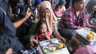 Warga menyantap hidangan Makan Bergizi Gratis (MBG) di kawasan Ciracas, Jakarta, Jumat (10/1/2025). [Suara.com/Alfian Winanto]