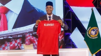 Pelatih sepak bola Timnas Indonesia, Patrick Kluivert menunjukan jersey Timnas bernamakan dirinya pada konferensi press perkenalan Tim Pelatih Timnas Indonesia yang baru di Hotel Mulia, Jakarta, Minggu, (12/01/2025). [Suara.com/Alfian Winanto]