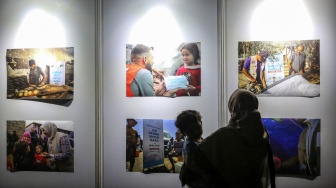 Pengunjung mengamati karya foto tentang bantuan kepada warga Palestina pada Palestine Festival di SMESCO Indonesia, Jakarta, Minggu (12/1/2025). [ANTARA FOTO/Asprilla Dwi Adha/foc]