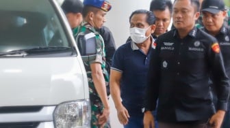 Mantan Ketua Pengadilan Negeri (PN) Surabaya, Rudi Suparmono (tengah) saat tiba di Kejaksaan Agung, Jakarta, Selasa (14/1/2025). [Suara.com/Alfian Winanto]