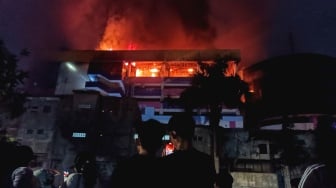 Warga melihat Gedung Glodok Plaza yang terbakar di Jakarta, Kamis (16/1/2025) dini hari. [Suara.com/Alfian Winanto]