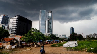 Penampakan awan mendung yang menyelimuti permukiman dan gedung bertingkat di Jakarta, Senin (20/1/2025). [Suara.com/Alfian Winanto]