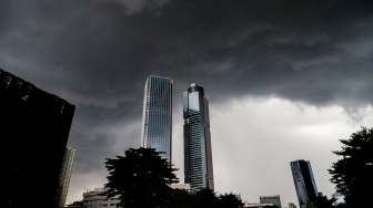 Penampakan awan mendung yang menyelimuti permukiman dan gedung bertingkat di Jakarta, Senin (20/1/2025). [Suara.com/Alfian Winanto]