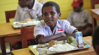 Siswa bersiap menyantap menu makan bergizi gratis perdana di SD Santo Michael Bilogae, Distrik Sugapa, Kabupaten Intan Jaya, Papua Tengah, Senin (20/1/2025). [ANTARA FOTO/Martinus Eguay/app/tom]