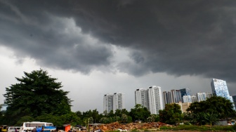 Penampakan awan mendung yang menyelimuti permukiman dan gedung bertingkat di Jakarta, Senin (20/1/2025). [Suara.com/Alfian Winanto]