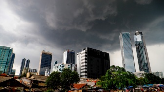 Penampakan awan mendung yang menyelimuti permukiman dan gedung bertingkat di Jakarta, Senin (20/1/2025). [Suara.com/Alfian Winanto]