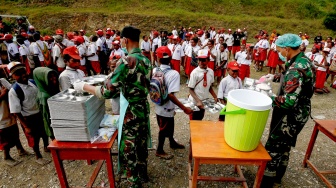 Anggota TNI melayani siswa yang mengantre untuk mendapatkan menu makan bergizi gratis perdana di SD Santo Michael Bilogae, Distrik Sugapa, Kabupaten Intan Jaya, Papua Tengah, Senin (20/1/2025). [ANTARA FOTO/Martinus Eguay/app/tom]