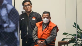 Petugas menggiring Bupati Situbondo nonaktif Karna Suswandi usai menjalani pemeriksaan di Gedung Merah Putih KPK, Jakarta, Selasa (21/1/2025). [Suara.com/Alfian Winanto]