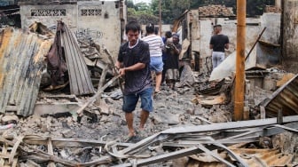 Warga mengambil barang sisa kebakaran di pemukiman padat penduduk, kawasan Kemayoran, Jakarta, Selasa (21/1/2025). [Suara.com/Alfian Winanto]