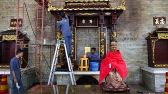 Warga keturunan Tionghoa membersihkan area ibadah di Vihara Amurva Bhumi, Jakarta, Rabu (22/1/2025). [Suara.com/Alfian Winanto]