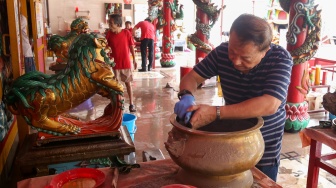 Warga keturunan Tionghoa membersihkan area ibadah di Vihara Amurva Bhumi, Jakarta, Rabu (22/1/2025). [Suara.com/Alfian Winanto]