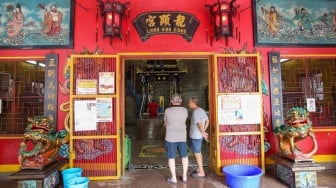 Warga keturunan Tionghoa membersihkan area ibadah di Vihara Amurva Bhumi, Jakarta, Rabu (22/1/2025). [Suara.com/Alfian Winanto]