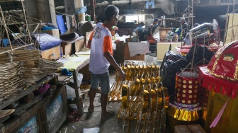 Perajin membuat replika barang-barang untuk sembahyang yang terbuat dari kertas di Kolong Tol Gedong Panjang, Jakarta, Kamis (23/1/2025). [Suara.com/Alfian Winanto]