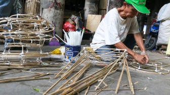 Perajin membuat replika barang-barang untuk sembahyang yang terbuat dari kertas di Kolong Tol Gedong Panjang, Jakarta, Kamis (23/1/2025). [Suara.com/Alfian Winanto]