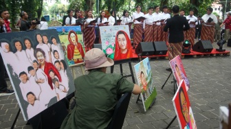 Seniman melukis wajah Megawati Soekarnoputri di Taman Suropati, Jakarta, Kamis (23/1/2025). [Suara.com/Alfian Winanto]