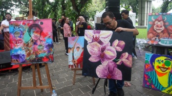 Seniman melukis wajah Megawati Soekarnoputri di Taman Suropati, Jakarta, Kamis (23/1/2025). [Suara.com/Alfian Winanto]