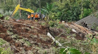 Petugas gabungan menggunakan alat berat saat mencari korban longsor di Dusun Jumok, Desa Sambirejo, Kecamatan Wonosalam, Kabupaten Jombang, Jawa Timur, Jumat (24/1/2025). [ANTARA FOTO/Syaiful Arif/nym]