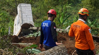 Petugas melihat bangunan rumah yang terdampak longsor di Dusun Jumok, Desa Sambirejo, Kecamatan Wonosalam, Kabupaten Jombang, Jawa Timur, Jumat (24/1/2025). [ANTARA FOTO/Syaiful Arif/nym]