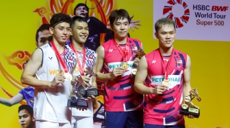 Pebulu Tangkis Ganda Putra Indonesia, Fajar Alfian dan Muhammad Rian Ardianto bersama Pebulu Tangkis Ganda Putra Malaysia Man Wei Chong dan Kai Wun Tee menunjukan medali dan piala usai pertandingan final Daihatsu Indonesia Masters 2025 di Istora Senayan, Jakarta, Minggu (26/1/2025). [Suara.com/Alfian Winanto]
