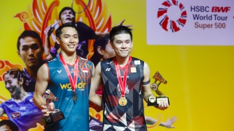 Pebulu Tangkis Tunggal Putra Indonesia, Jonatan Christie bersama Pebulu Tangkis Tunggal Putra Thailand, Kunlavut Vitidsarn menunjukan medali dan piala pada final Daihatsu Indonesia Masters 2025 di Istora Senayan, Jakarta, Minggu (26/1/2025). [Suara.com/Alfian Winanto]
