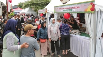 Pembeli memilih ikan dalam acara Festival Bandeng Rawa Belong di Jakarta, Senin (27/1/2025). [Suara.com/Alfian Winanto]