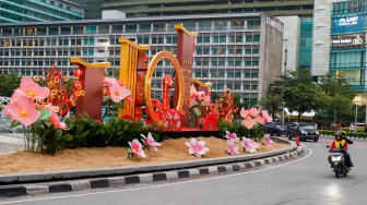 Sejumlah pengendara sepeda motor melintasi dekorasi Tahun Baru Imlek di Bundaran HI, Jakarta, Senin (27/1/2025). [Suara.com/Alfian Winanto]