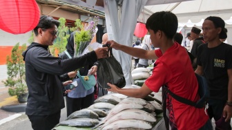 Pembeli memilih ikan dalam acara Festival Bandeng Rawa Belong di Jakarta, Senin (27/1/2025). [Suara.com/Alfian Winanto]