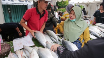 Pembeli memilih ikan dalam acara Festival Bandeng Rawa Belong di Jakarta, Senin (27/1/2025). [Suara.com/Alfian Winanto]